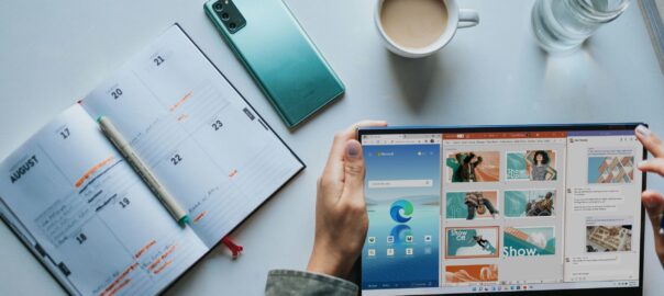 person using Windows 11 computer beside white ceramic mug on white table